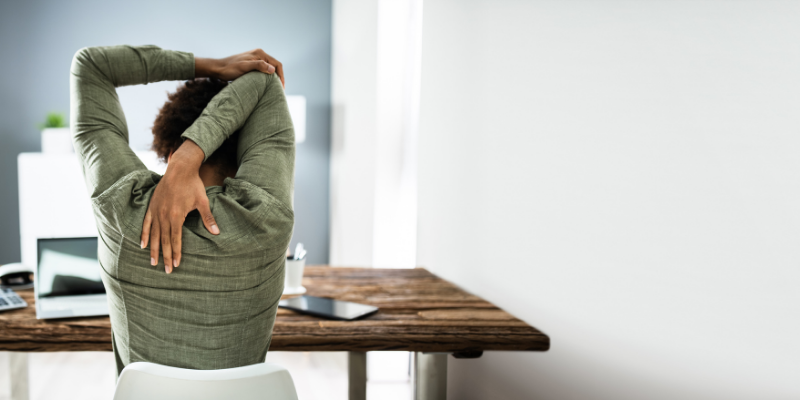 Person stretching at desk